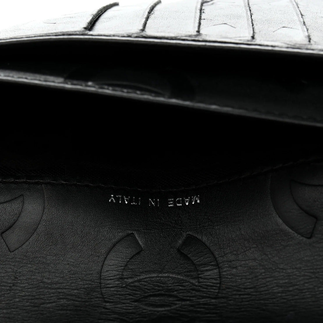 Close-up of a black leather handbag with embossed patterns and 'ATLANTA' branding.