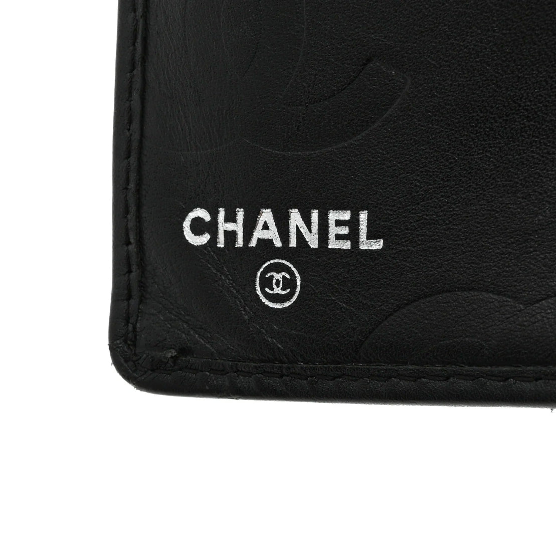 Close-up of a Chanel logo on a black leather product.