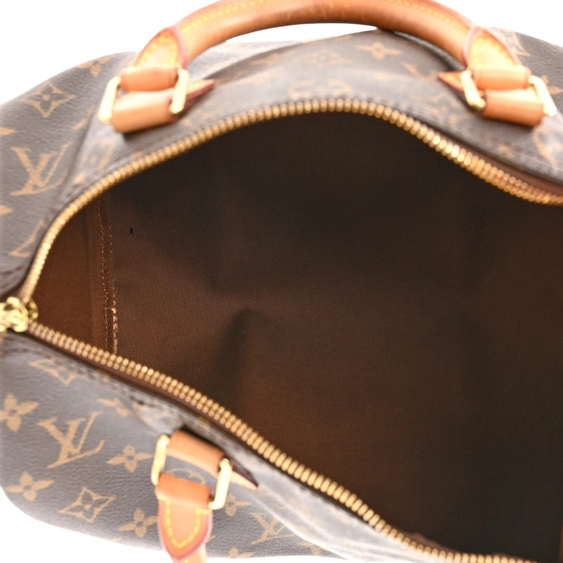 Close-up of a brown leather handbag with gold hardware and monogram pattern.