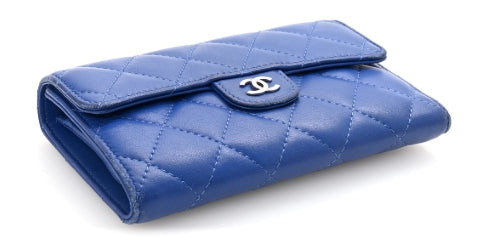 Blue quilted wallet with Chanel logo on a white background