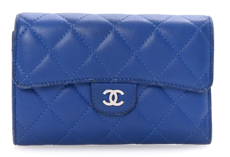 Blue quilted wallet with Chanel logo on a white background