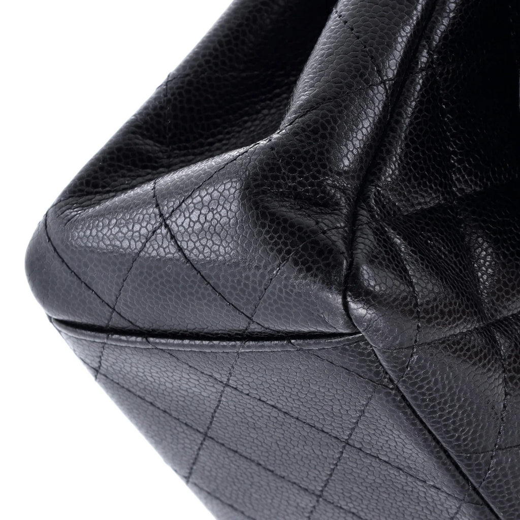 Chanel Classic Double Flap Bag Quilted Caviar Maxi Close-up of a black quilted handbag with visible stitching details.