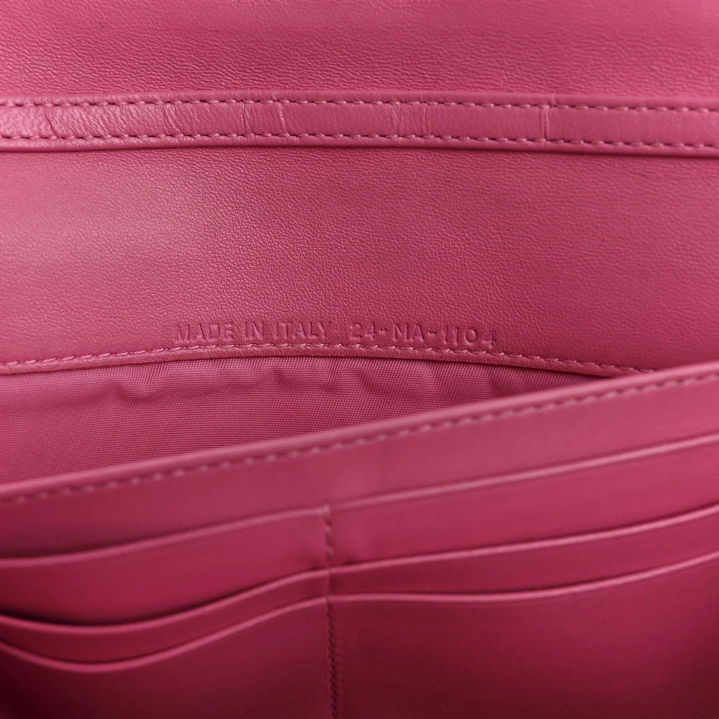 Close-up of a pink leather product with 'Made in Italy' label.