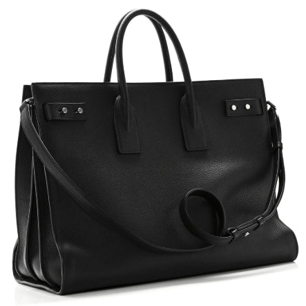 Black leather handbag with a strap on a white background