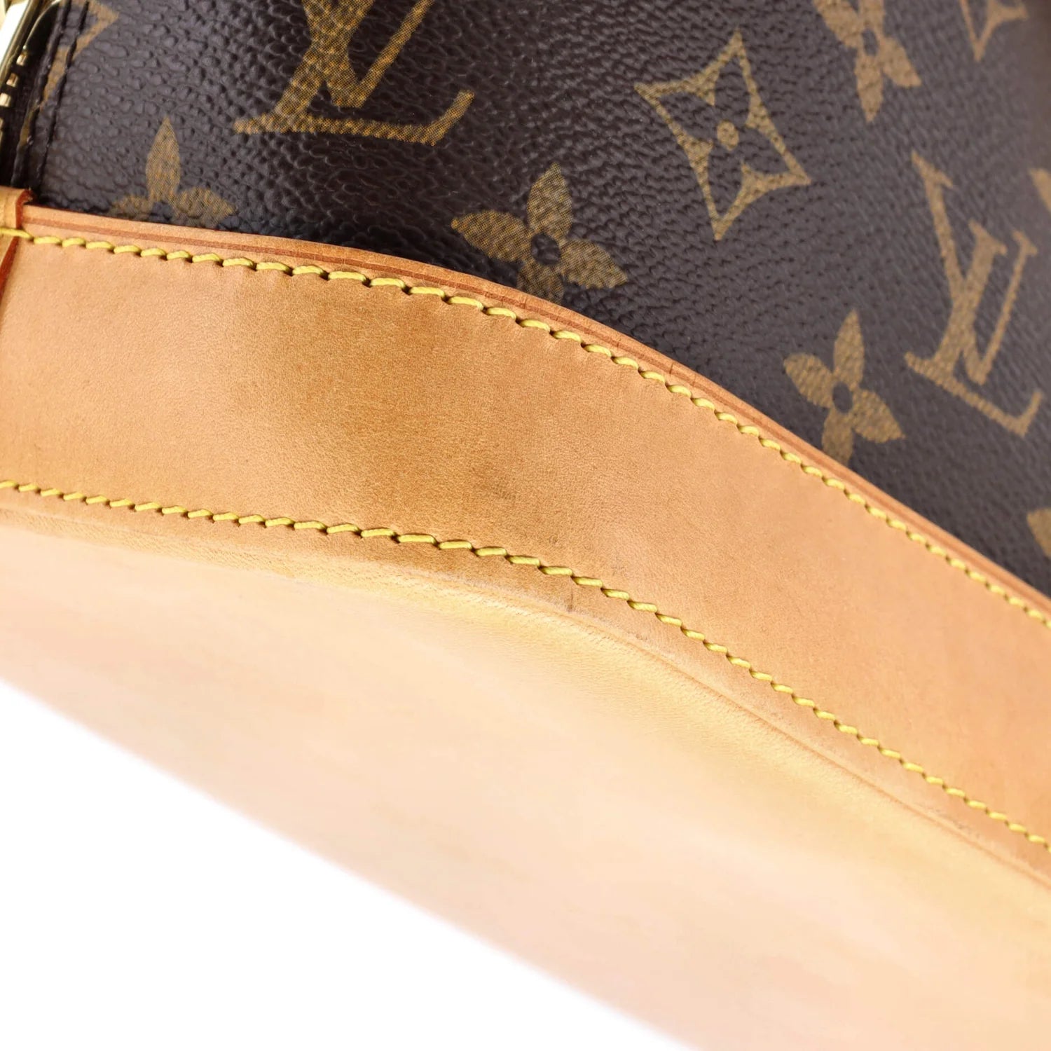 Close-up of a Louis Vuitton handbag with monogram pattern and beige interior.