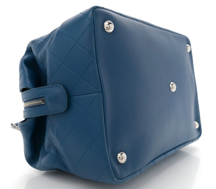 chanel Blue quilted handbag with silver studs on a white background