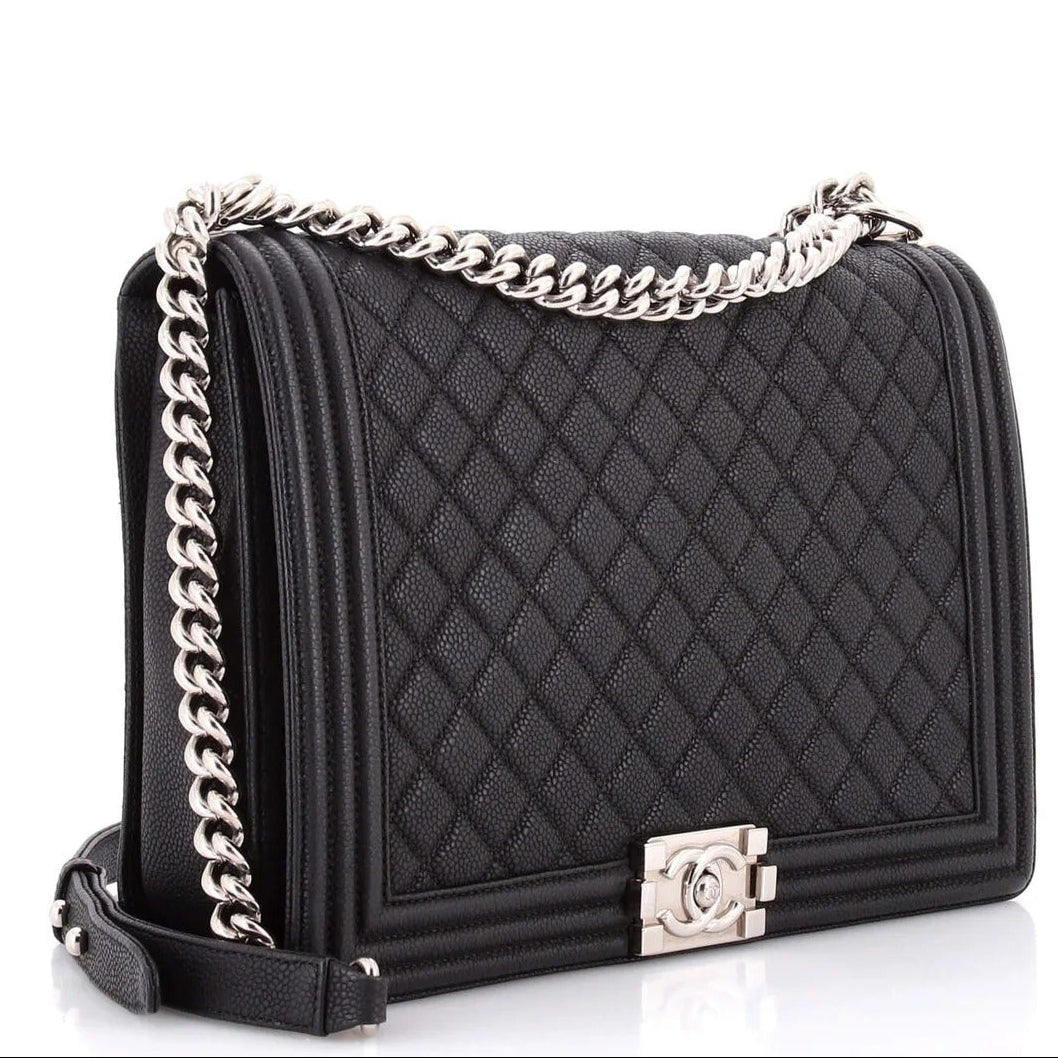 chanel caviar boy flap bag large Black quilted handbag with a silver chain strap on a white background