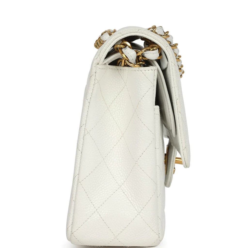 White quilted handbag with gold chain detail on a white background
