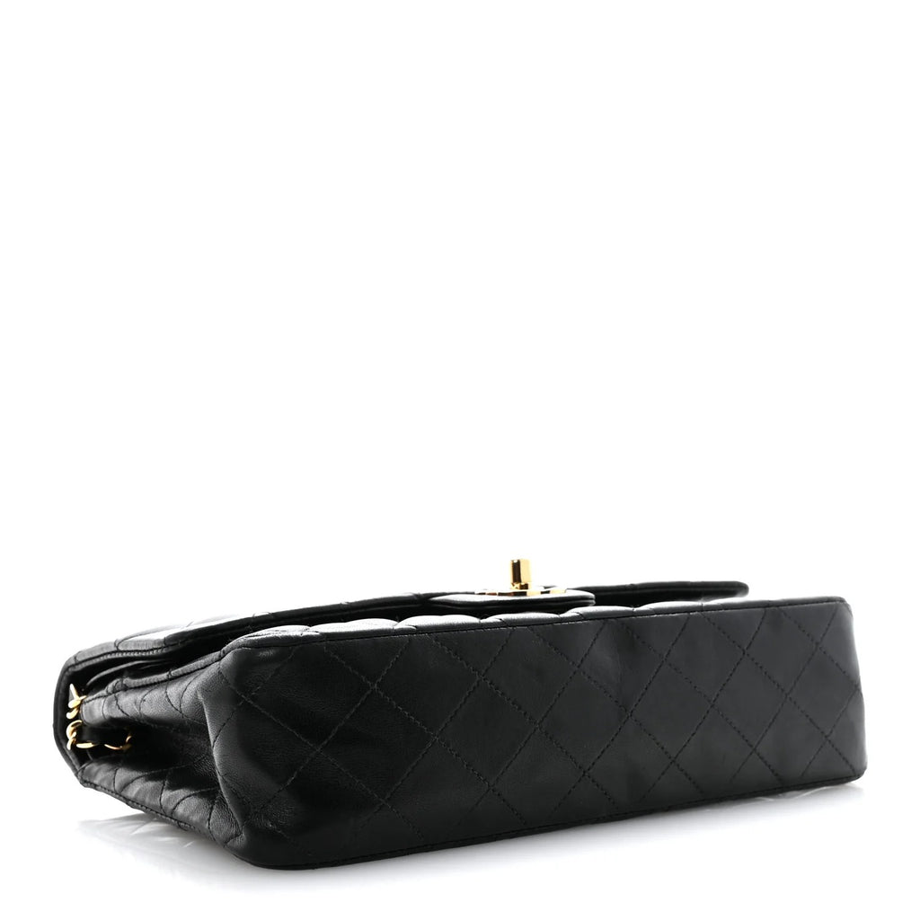 chanel lambskin medium double flap  Black quilted handbag with gold hardware on a white background