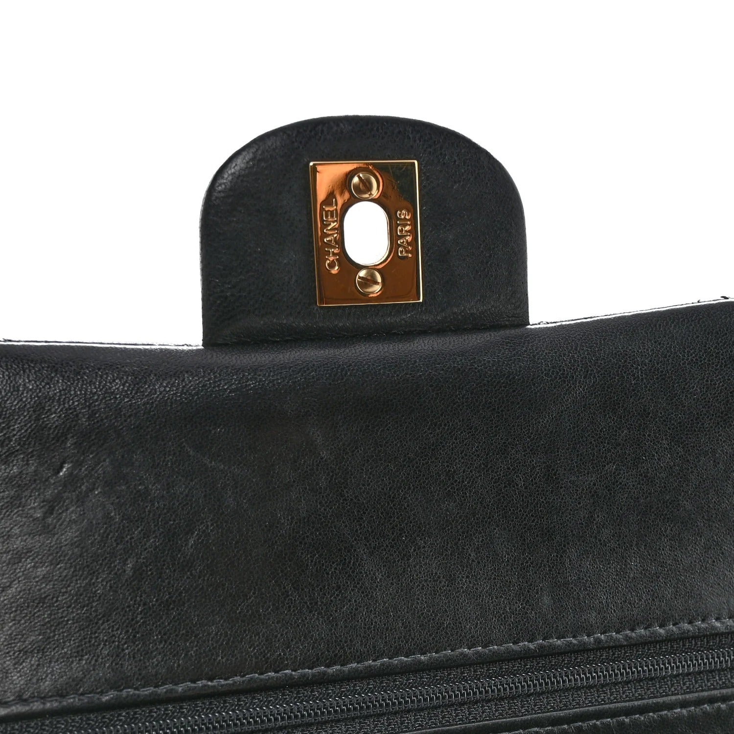 chanel lambskin medium double flap  Close-up of a black leather handbag with a gold Chanel logo on a white background