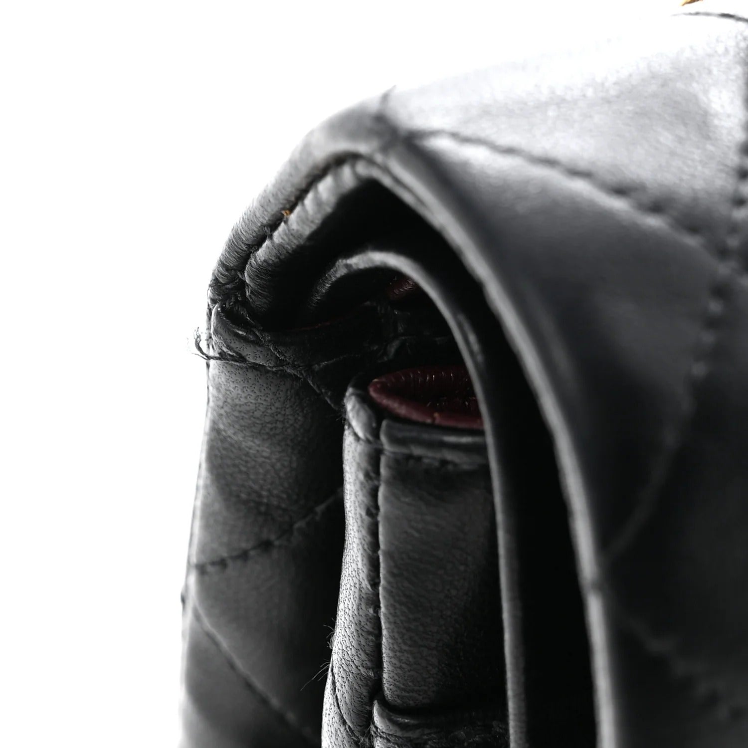 chanel lambskin medium double flap 
Close-up of a black leather glove with stitching details on a white background
