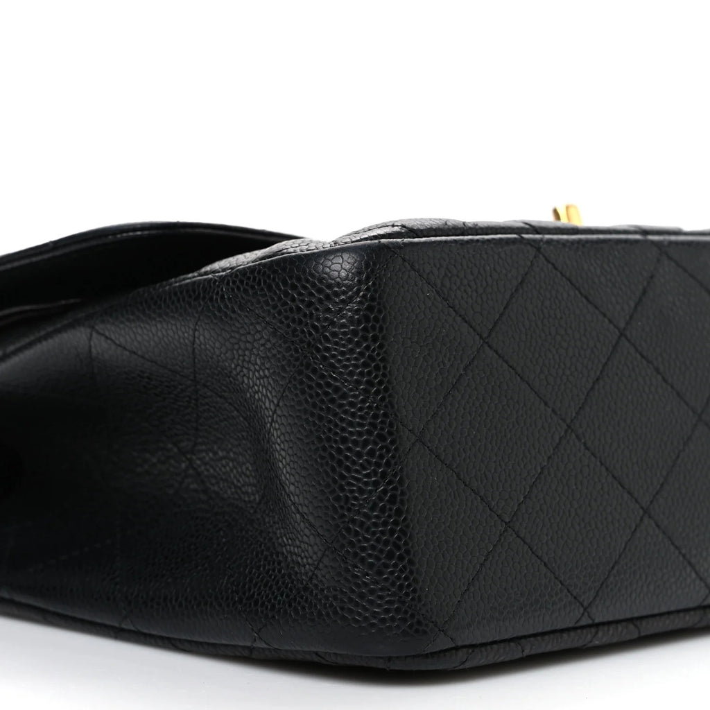 Close-up of a black quilted handbag on a white background