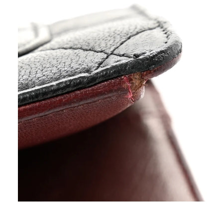Close-up of a brown leather product with visible stitching chanel wallet 