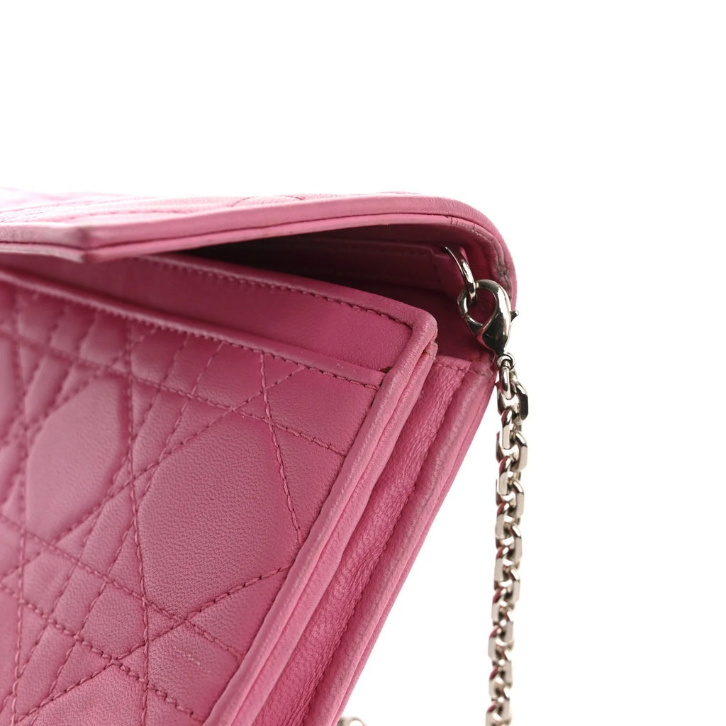 Close-up of a pink quilted handbag with a chain strap on a white background