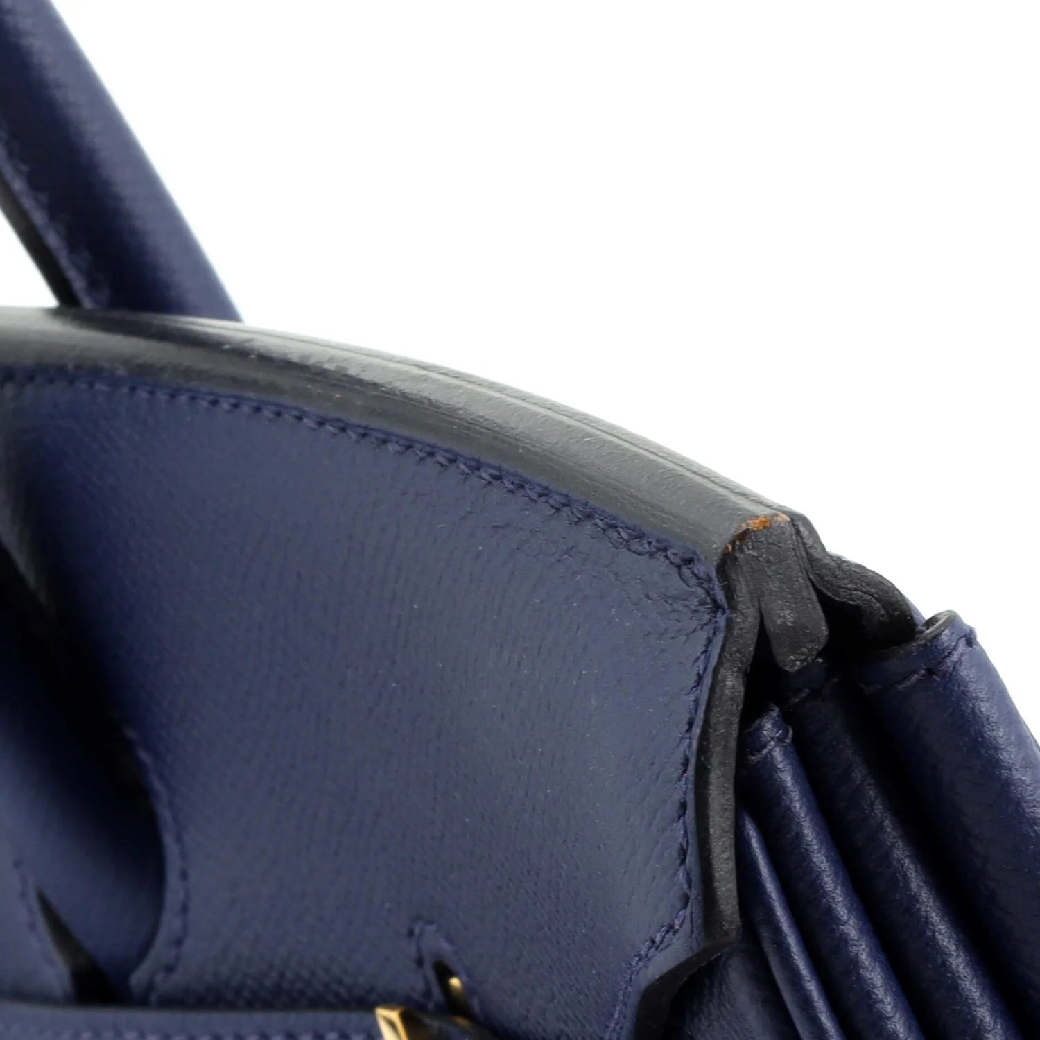 Close-up of a blue Hermes Birkin  handbag with visible stitching on a white background