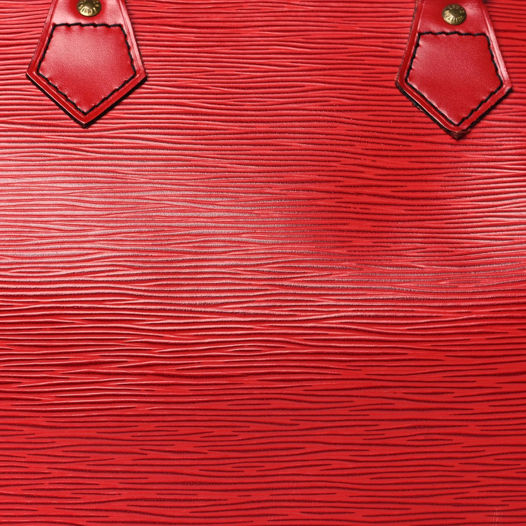 Close-up of a red textured leather surface with gold accents.