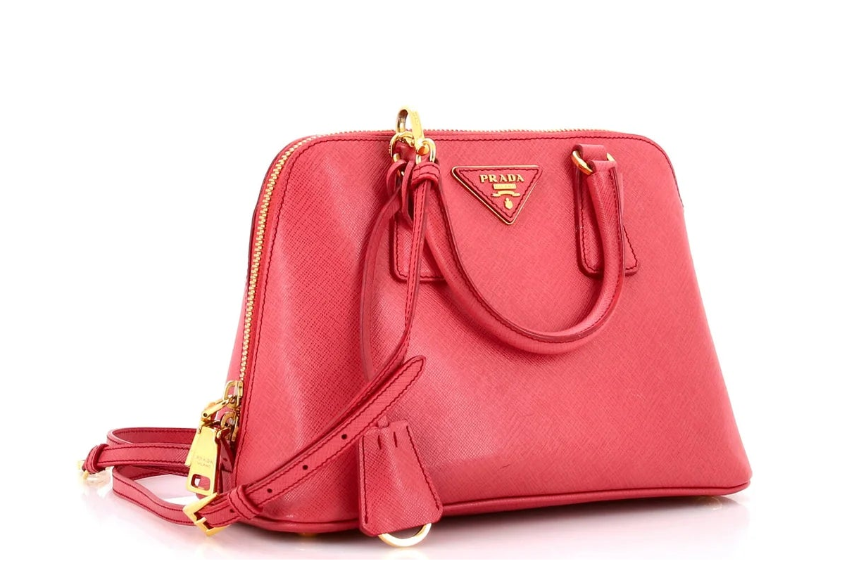 Pink Prada leather handbag with gold accents on a white background