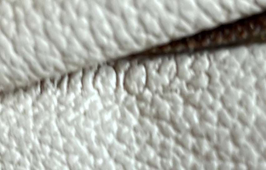 Close-up of textured white fabric with a dark line running through it