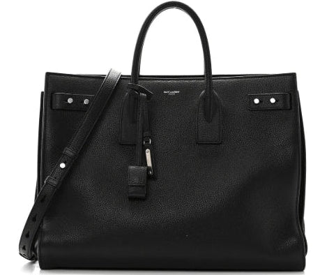 Black leather handbag with a shoulder strap on a white background